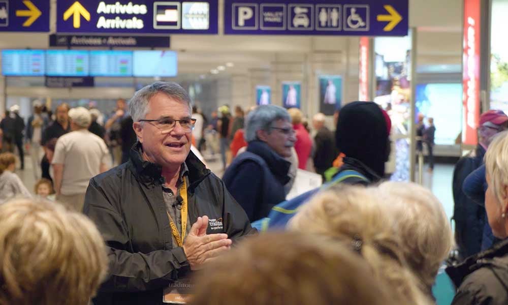Accompagnateur qui accueille un groupe de voyageurs à l'aéroport