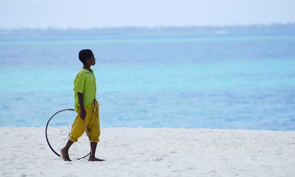 Enfant-marchant-sur-une-plage-de-zanzibar