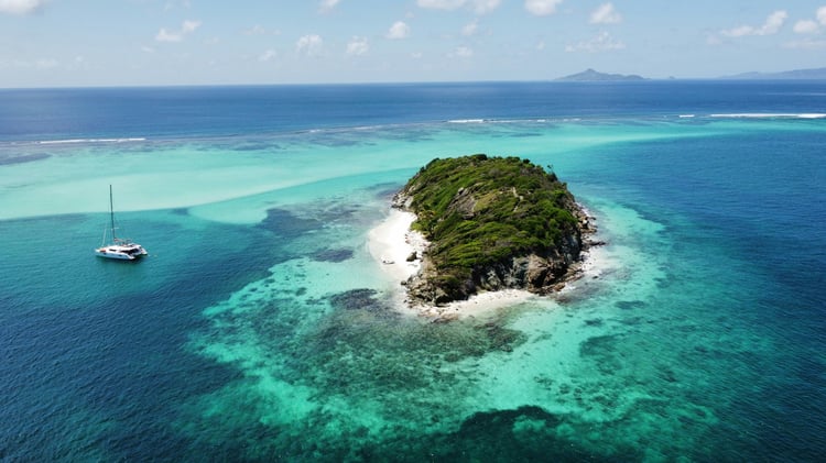 Vue d'une île de Tobogo Cays avec catamaran