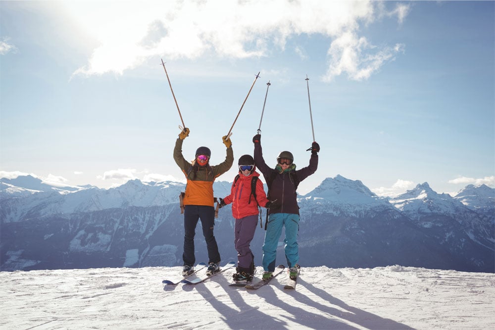 Trois skieurs heureux sur le sommet d'une montagne couverte de neige