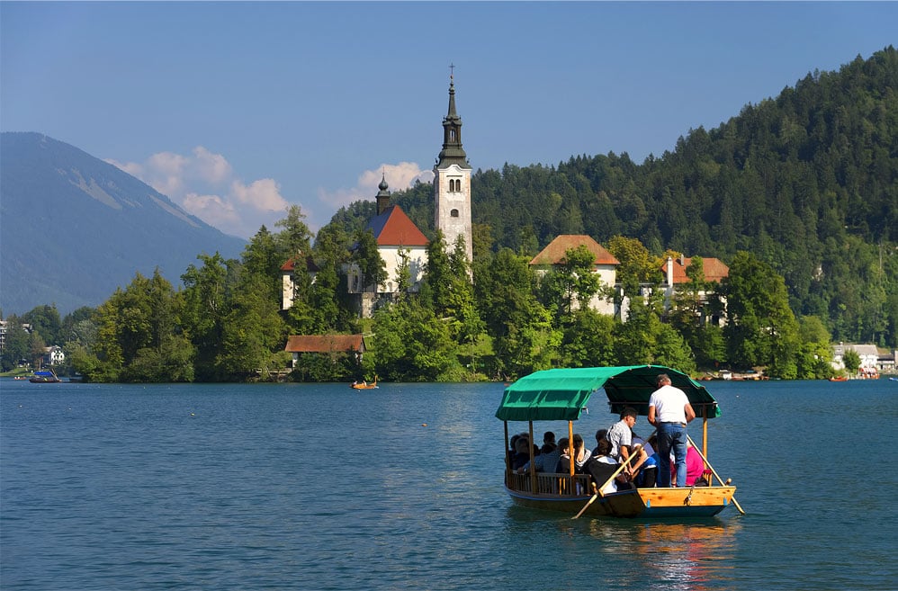 Embarcation avec passagers naviguant sur le lac de Bohinj en Slovénie.